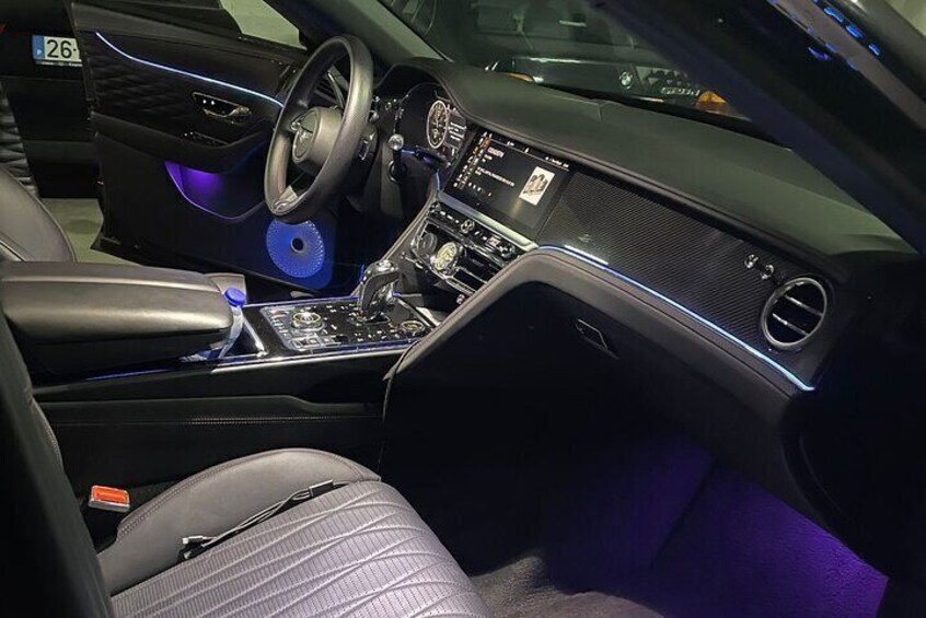 A luxury car interior with a digital dashboard, leather seats, and ambient lighting. 5