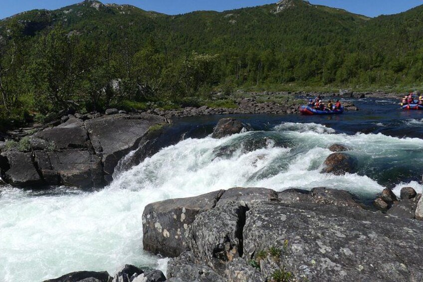 Un río con rápidos, rodeado de terreno rocoso y colinas boscosas. 4