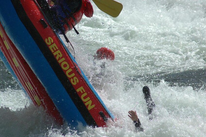 Una canoa blanca con diseño rojo y azul, parcialmente sumergida en el agua. 3
