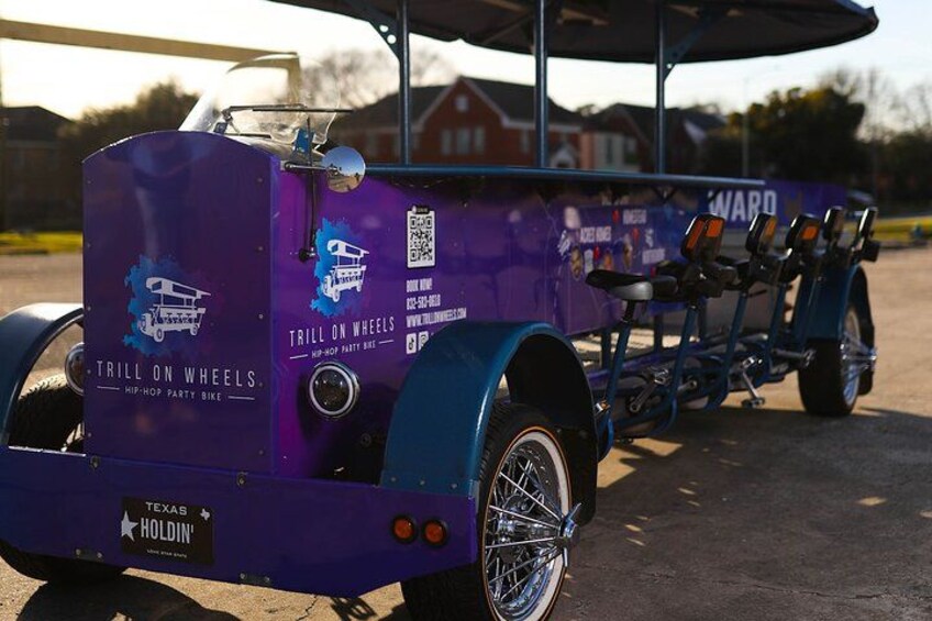 Un tricycle violet orné de l’inscription « Trill on Wheels » et portant l’inscription « Texas Holdem » à l’arrière. 3