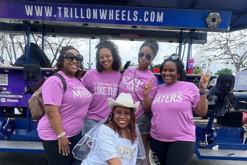A group of people wearing pink shirts with a website URL and a peace sign. 2