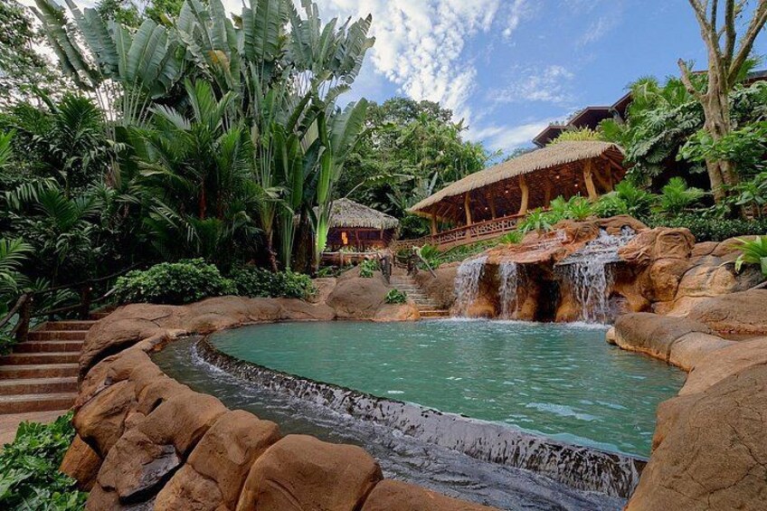 Un complexe hôtelier tropical doté d’une piscine, d’une cascade et d’une végétation luxuriante. 3