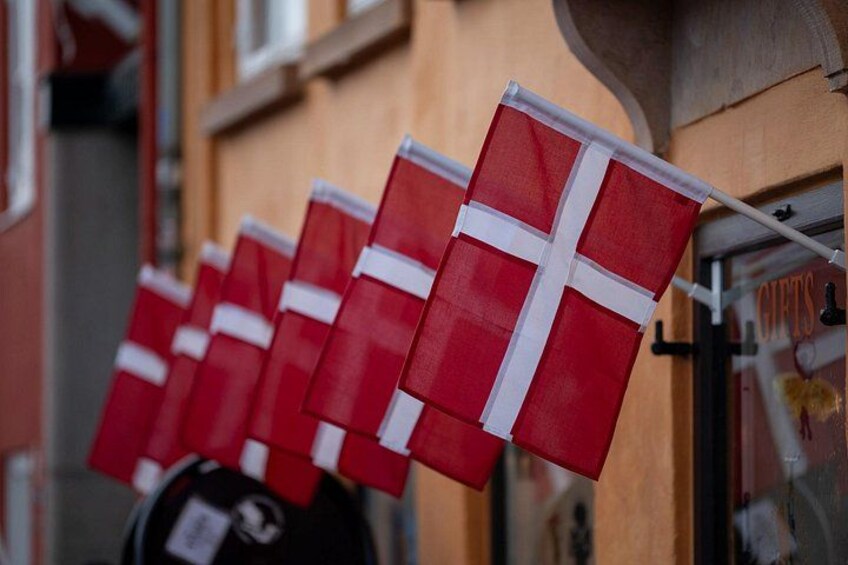 A row of red and white flags hanging on a building. 3
