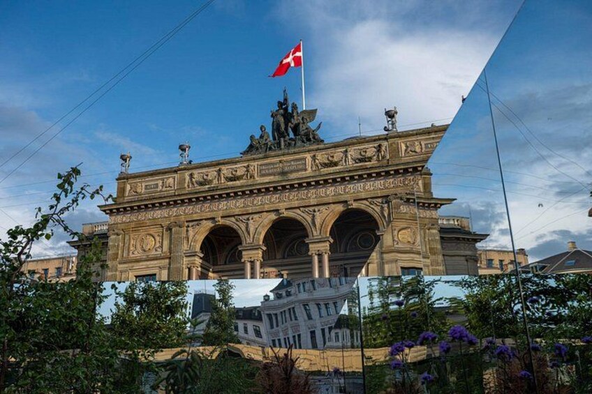 A historic building with ornate architecture, a flag, and a statue on top. 4