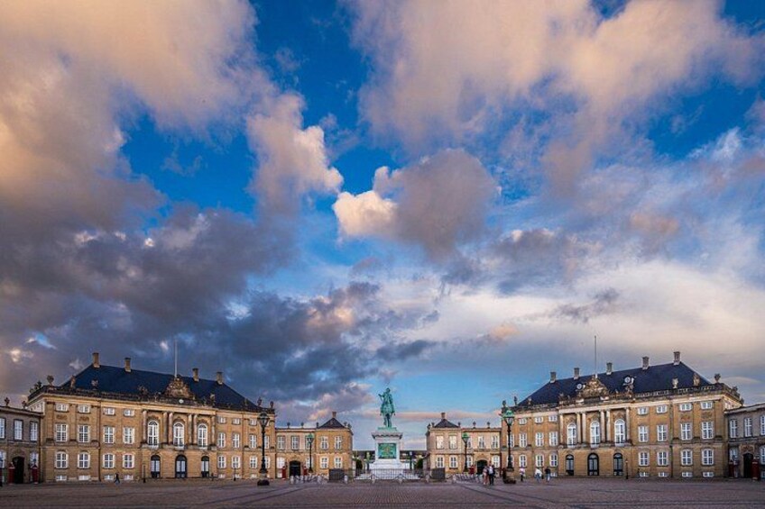 A historic building with a central statue, surrounded by a paved square. 5
