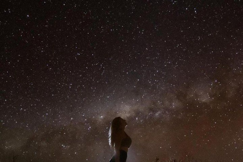 A person standing under a starry night sky. 2