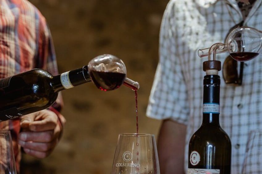 En person hælder vin fra en flaske i et glas. 2