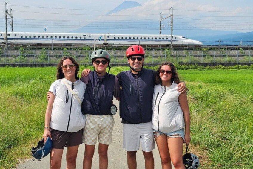 Four people standing on a path with a train in the background. 1