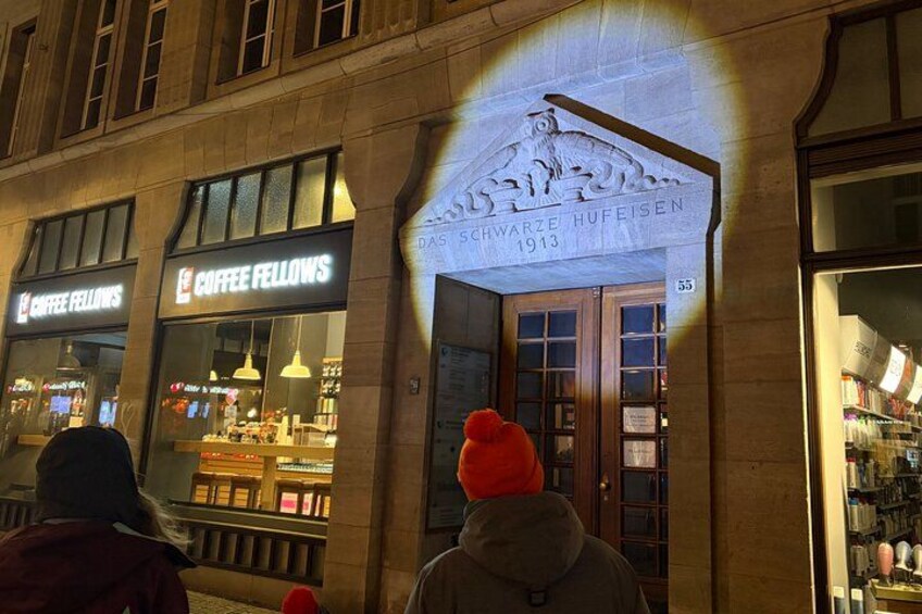 A building with a sign that reads 'SCHWARZE HUFEISEN 1913' and two storefronts labeled 'COFFEE FELLOWS.' 3