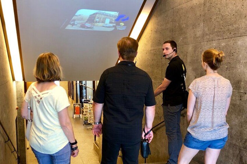 People walking in a hallway with a projection screen displaying a map. 2