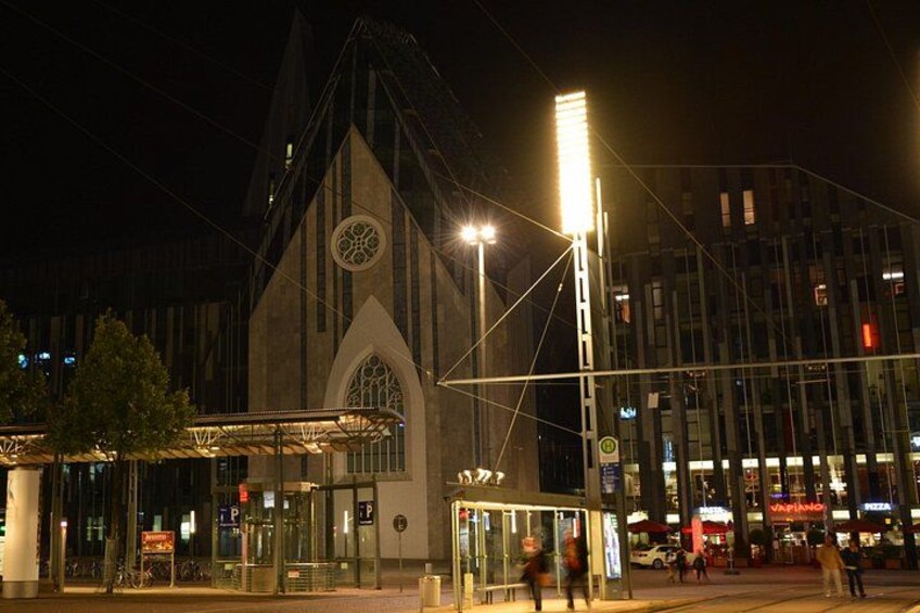 Un bâtiment moderne doté d’un toit en forme de flèche et d’une grande fenêtre circulaire située en haut. 2