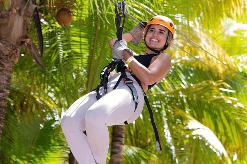 Una persona haciendo tirolesa por un bosque tropical. 1