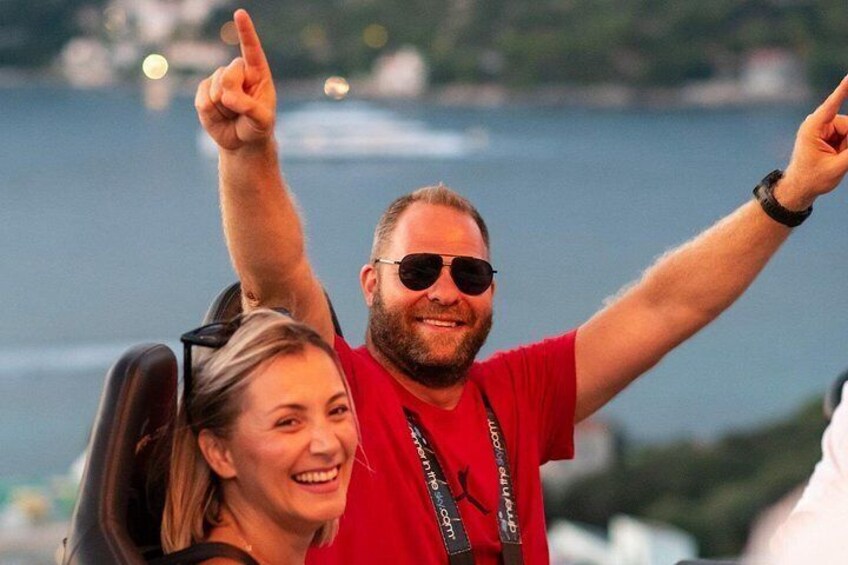 A person in a red shirt with a lanyard, pointing upwards. 3