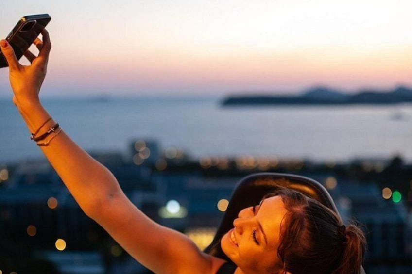 A person taking a selfie with a smartphone, holding it up with their right hand. 2