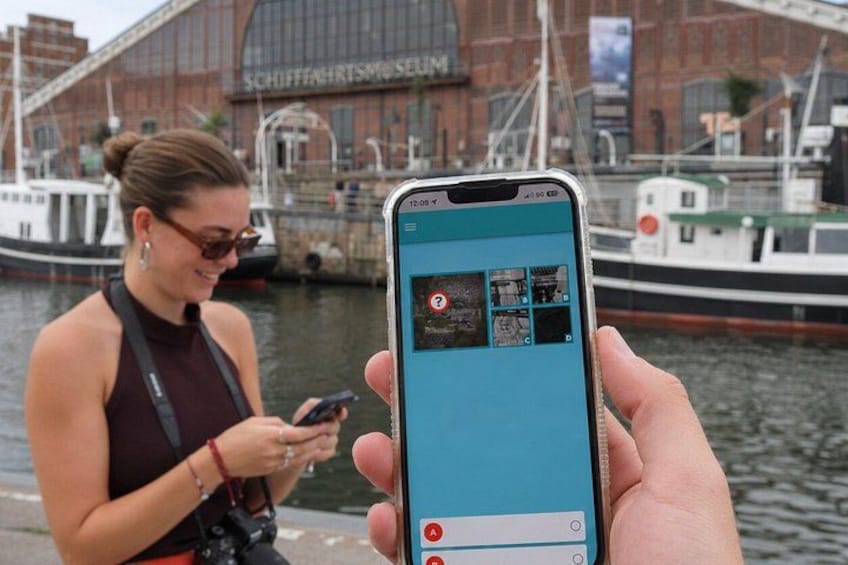 A person holding a smartphone displaying a map with multiple locations. 1