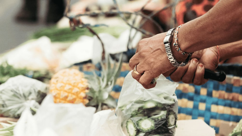 A person handling a plastic bag at a market. 3