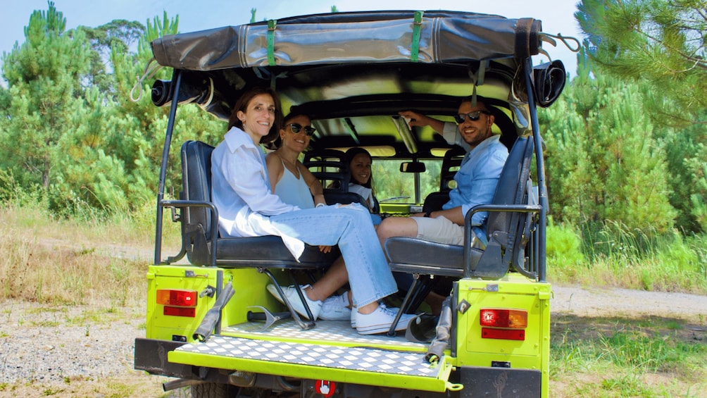 A yellow safari vehicle with passengers. 2