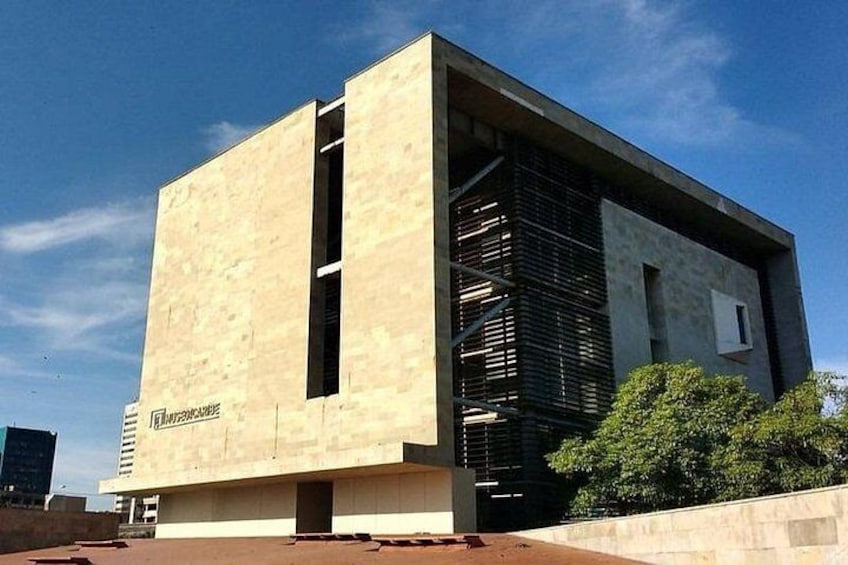 A modern building with a beige facade and a black vertical element. 5