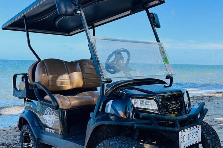 A golf cart on a beach with the ocean in the background. 5