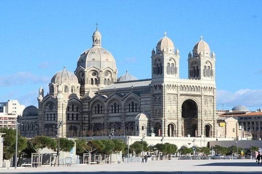 A large, ornate cathedral with multiple domes and towers, surrounded by a plaza with trees and benches. 3
