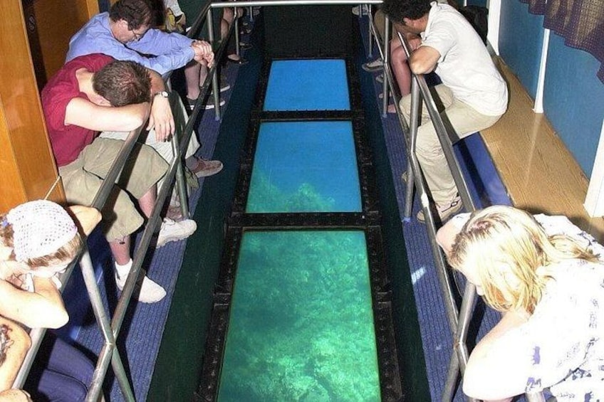 People leaning over a railing, looking at a water slide. 5