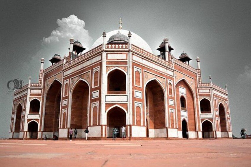 A large, historic building with domes and arches, surrounded by a red-tiled area. 2