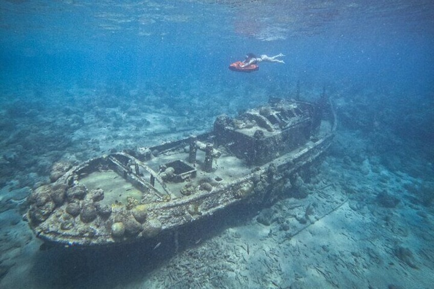 An underwater shipwreck with a diver in the background. 2