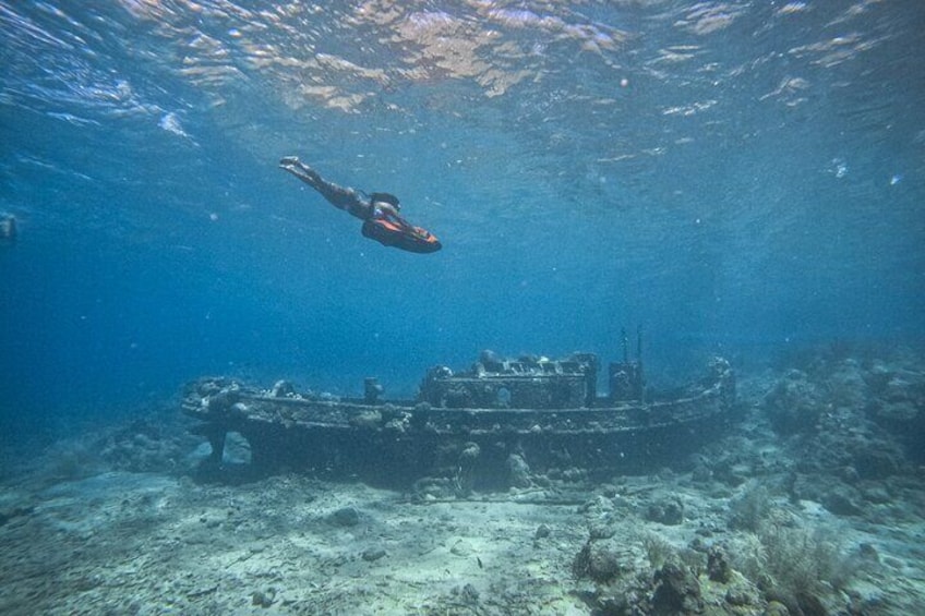 A diver swimming near a sunken shipwreck on the ocean floor. 5