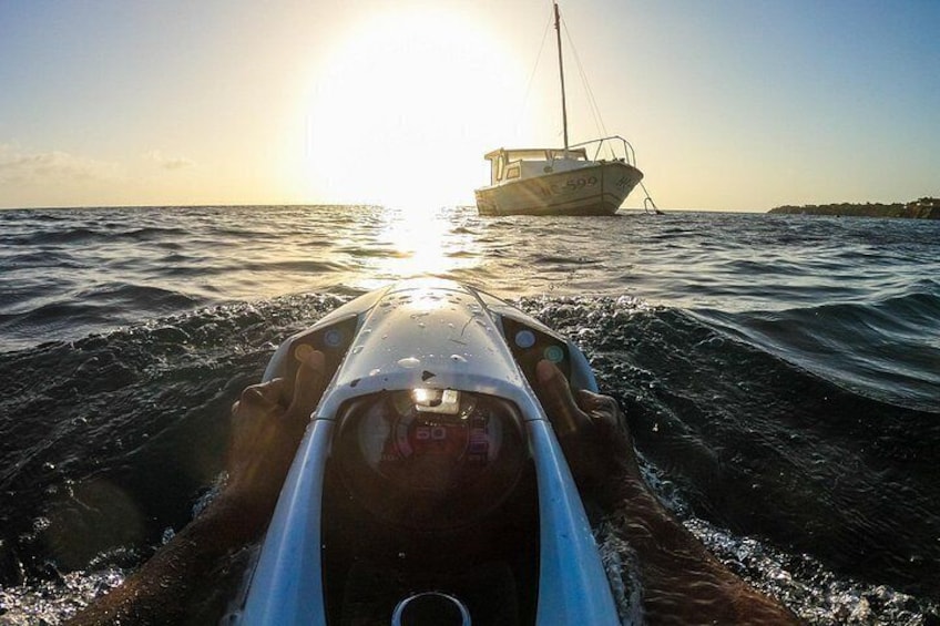 A person in a kayak on water with a boat in the background. 2