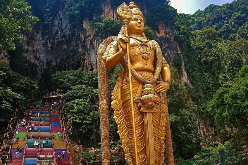 A large golden statue of a deity with a mountain backdrop. 2
