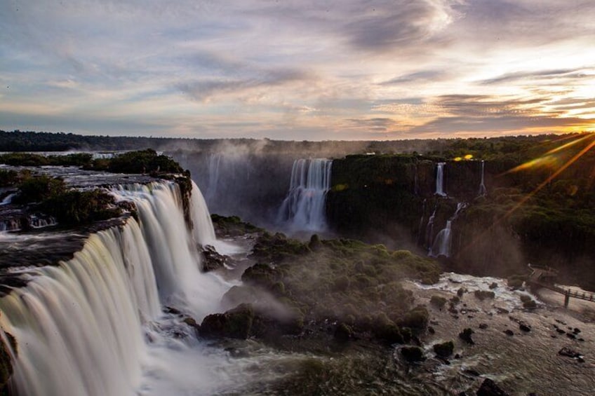 A waterfall cascading over a cliff with a sunset in the background. 3