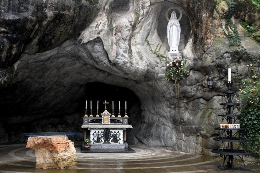 Una cueva con una estatua, un altar y velas. 3