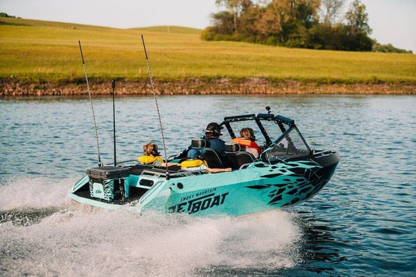 A speedboat with the text 'Speed Boat' on its side, moving on water with a grassy landscape in the background. 4
