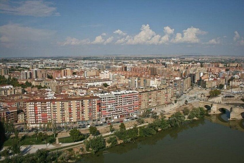 A cityscape with dense urban buildings, a river, and a bridge. 3
