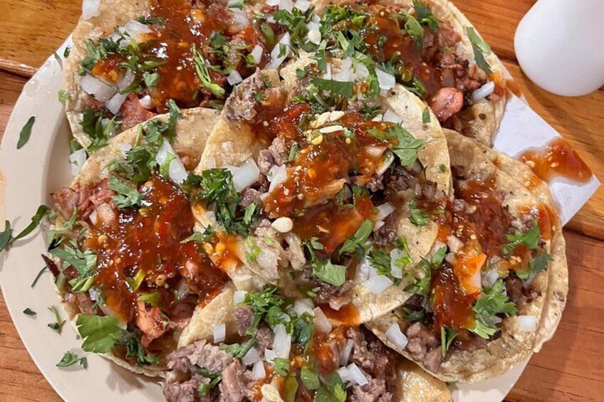 Un plato de tacos con carne, cebolla y cilantro. 5