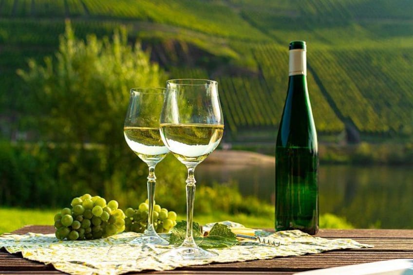 A vineyard landscape with two wine glasses and a bottle of wine on a table. 1