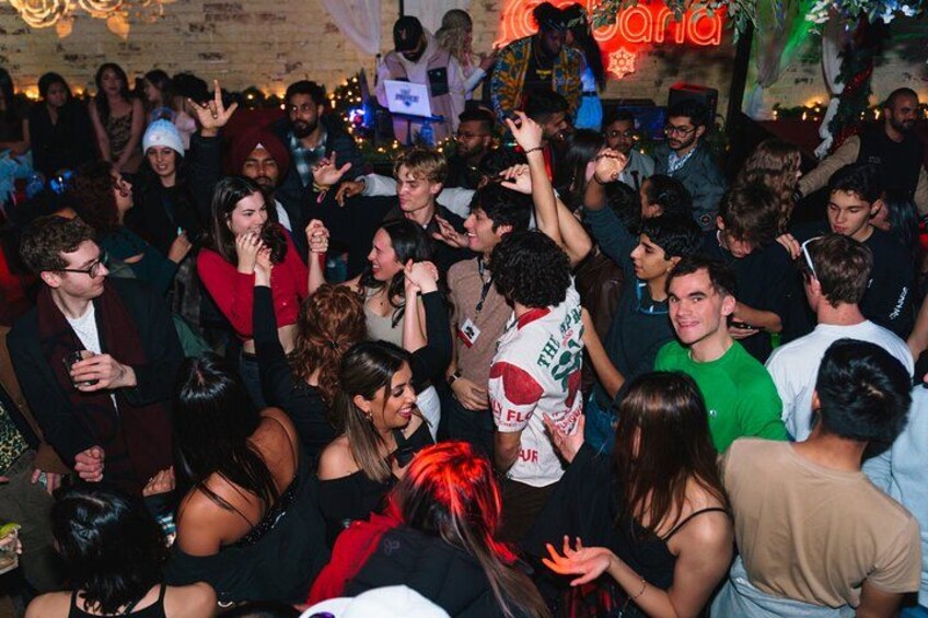 A crowded indoor event with people dancing and socializing. 2
