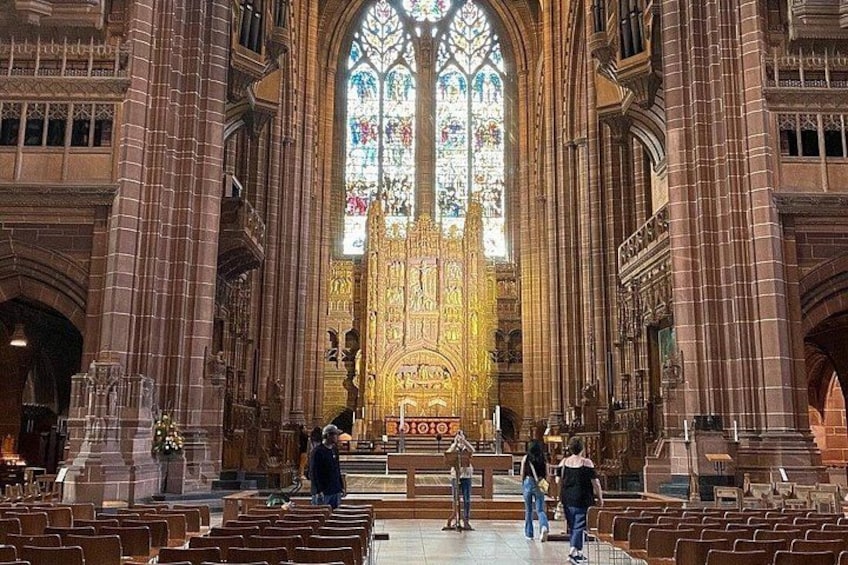 A cathedral interior with high vaulted ceilings, stained glass windows, and rows of pews. 3