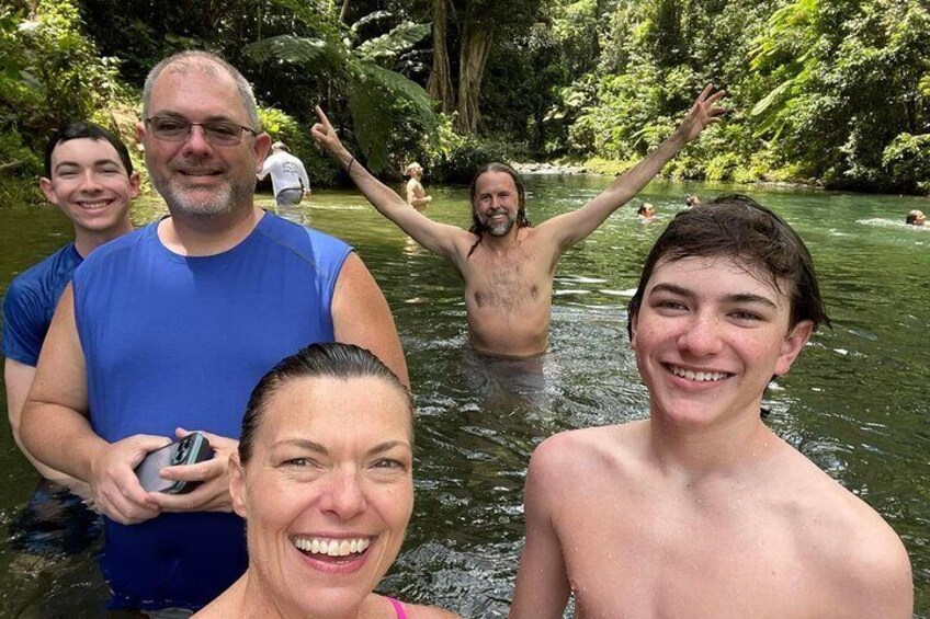 A group of people in a river surrounded by greenery. 1