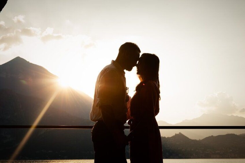 A couple embracing with a mountain and sun in the background. 2