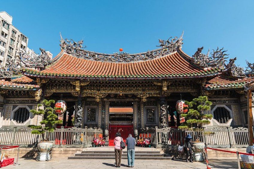 Ein traditioneller chinesischer Tempel mit aufwendiger Architektur, darunter ein geschwungenes Dach und filigrane Verzierungen. 4