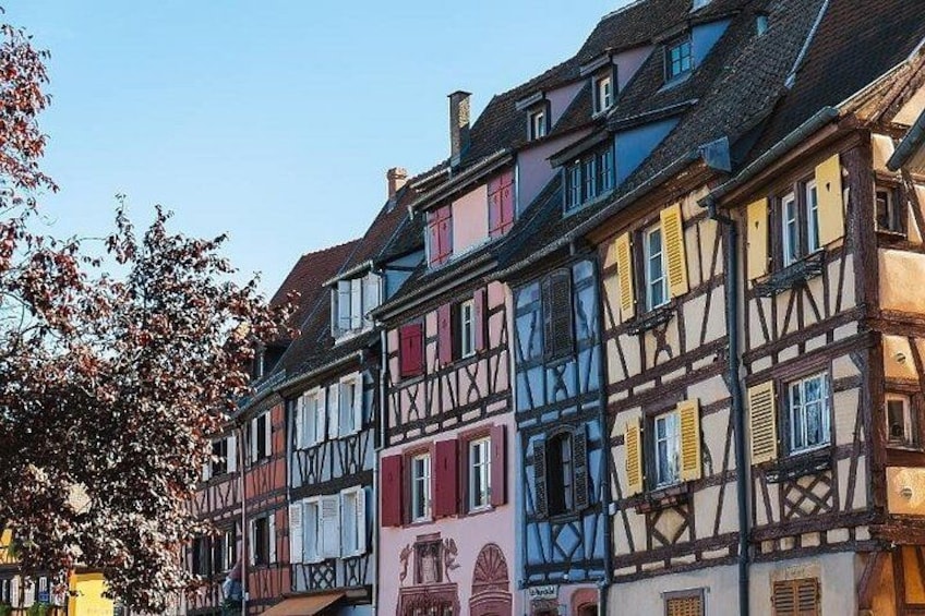 A row of colorful half-timbered houses with visible windows and shutters. 2