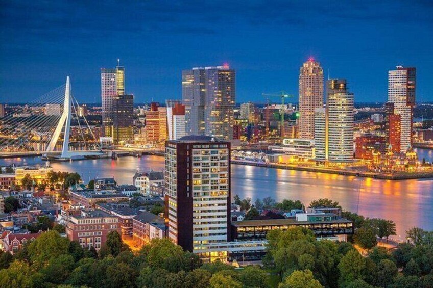 A city skyline at dusk with a prominent cable bridge and modern high-rise buildings. 4