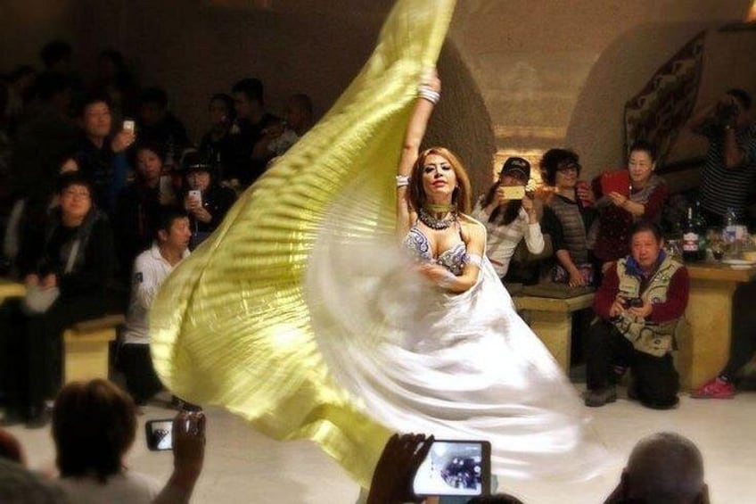 Una persona con vestido blanco actuando frente a un público. 1
