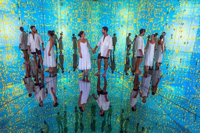 Un grupo de personas de pie sobre una superficie reflectante, mostrando múltiples reflejos. 2