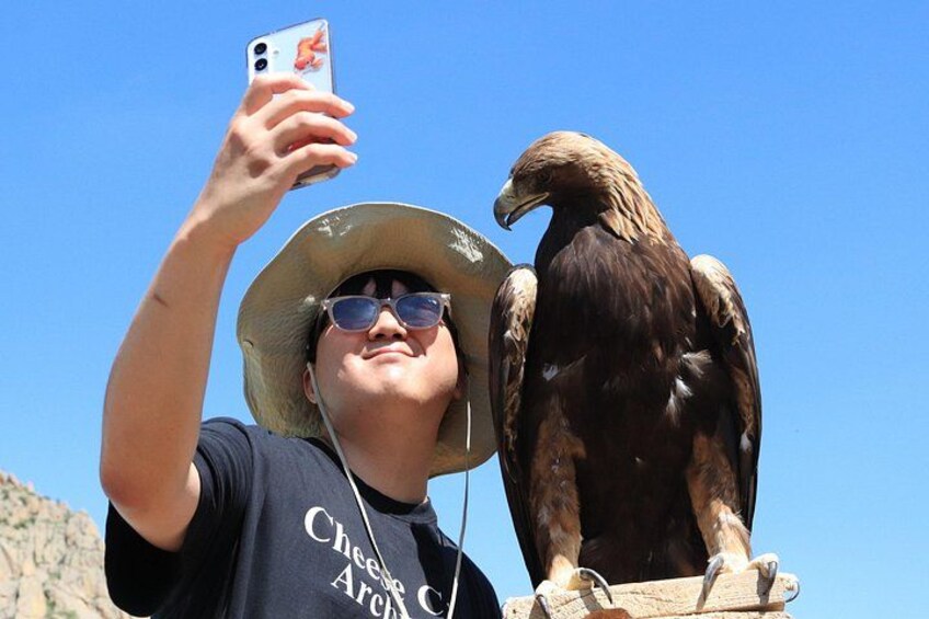 Iemand maakt een selfie met een vogel op zijn schouder. 2
