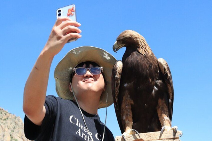 A person taking a selfie with a bird perched on their shoulder. 3