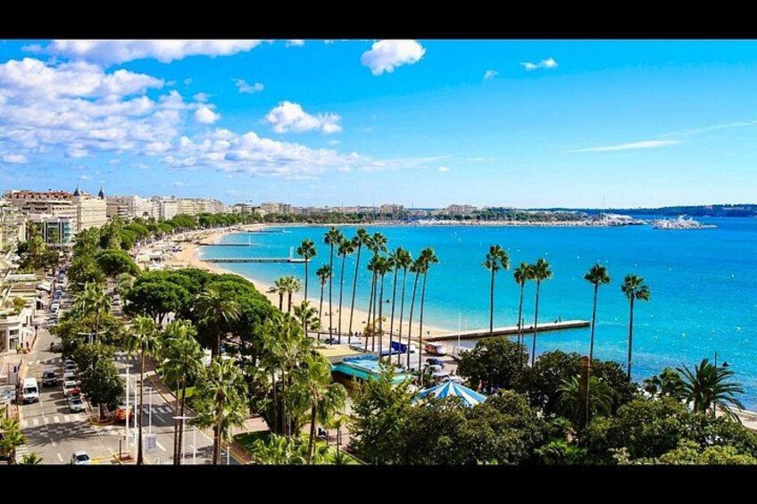 Un paisaje costero con playa, palmeras y cielo azul despejado. 1