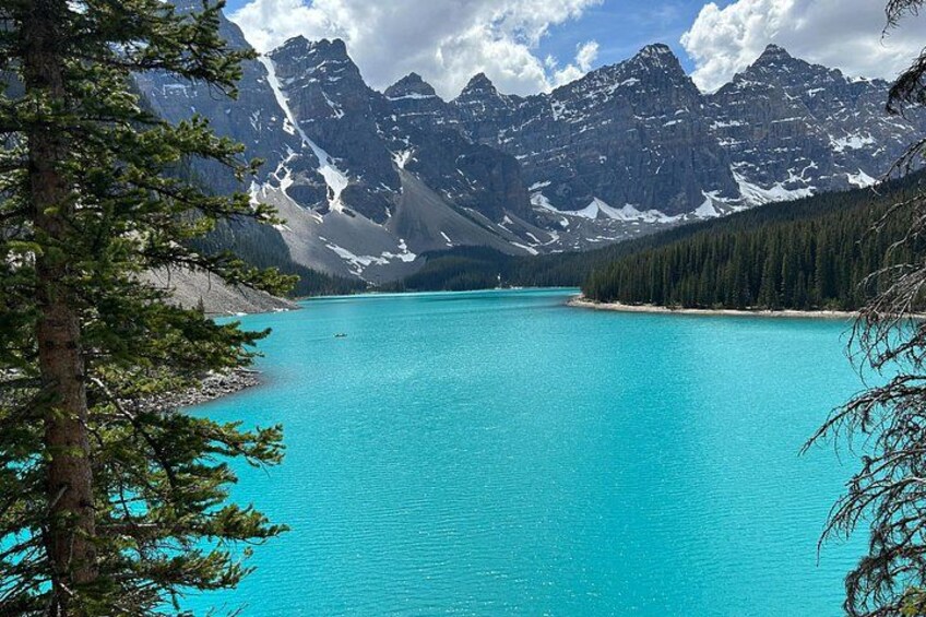A turquoise lake surrounded by mountains and dense forests. 2