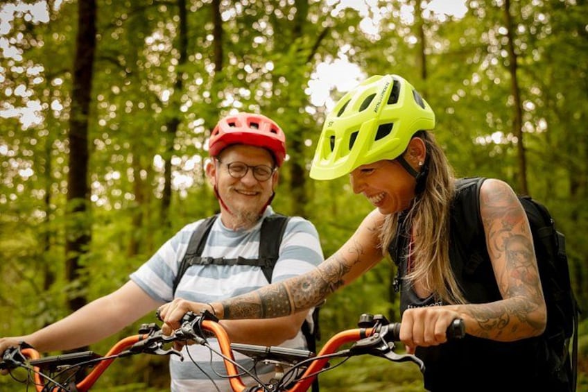 Two people on bicycles in a forested area. 3
